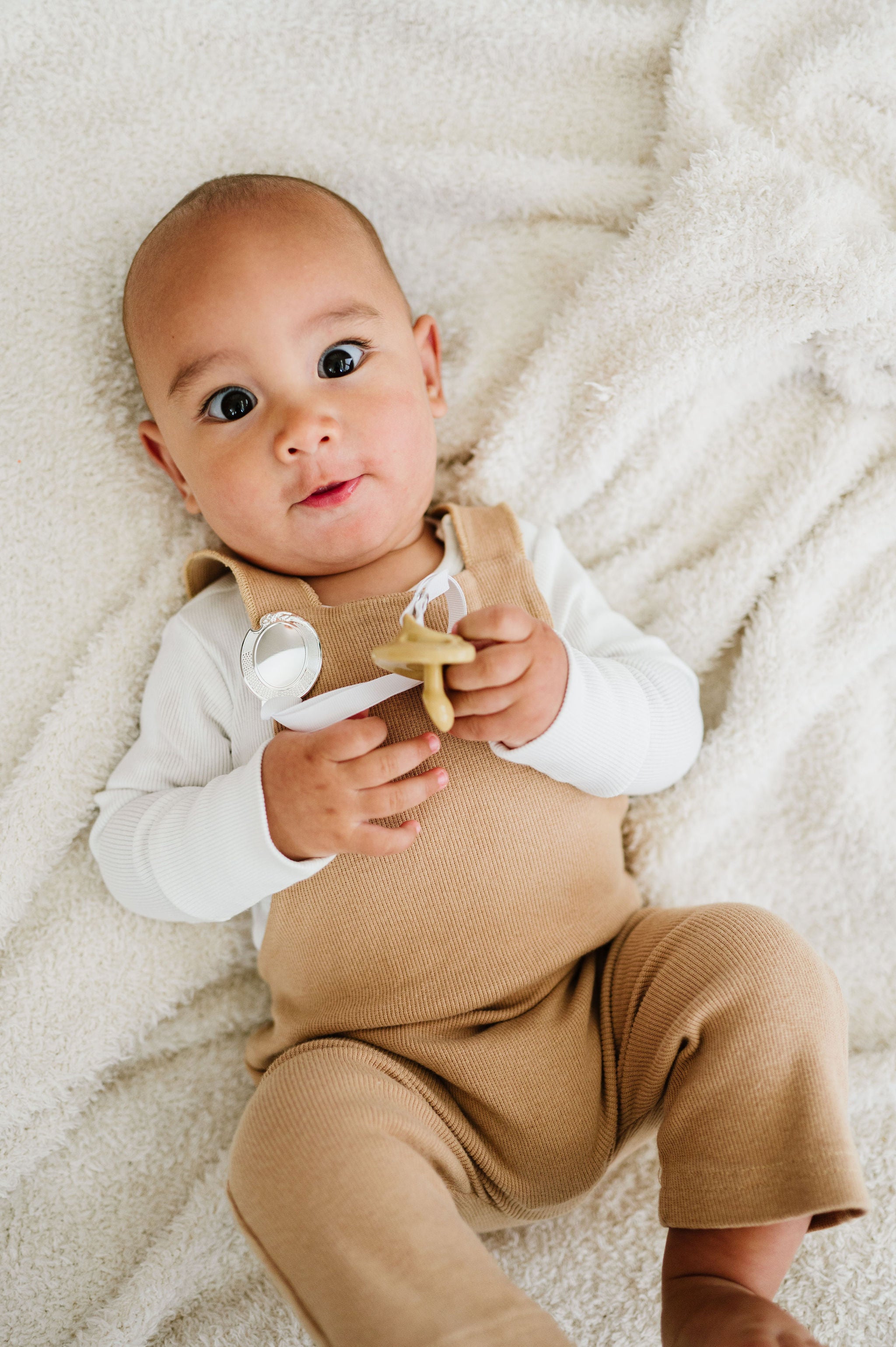 baby wearing a silver pacifier clip by Melonbug